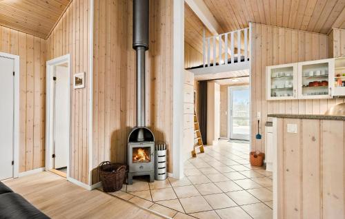 a fireplace in a living room with wooden walls at Holiday Home Fasanvænget Hemmet I in Hemmet