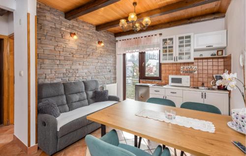 a kitchen and living room with a table and a couch at Nice Home In Fuzine With Kitchen in Fužine