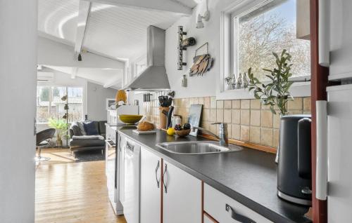 a kitchen with white cabinets and a sink at Two-Bedroom Holiday Home In Jagerspris in Jægerspris