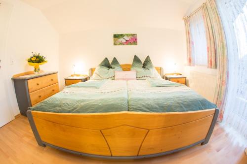 ein Schlafzimmer mit einem großen Holzbett in einem Zimmer in der Unterkunft Apart Dirndltal in Loich
