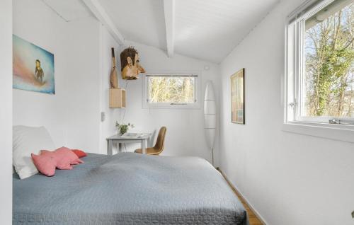 a white bedroom with a bed and a window at Two-Bedroom Holiday Home In Jagerspris in Jægerspris