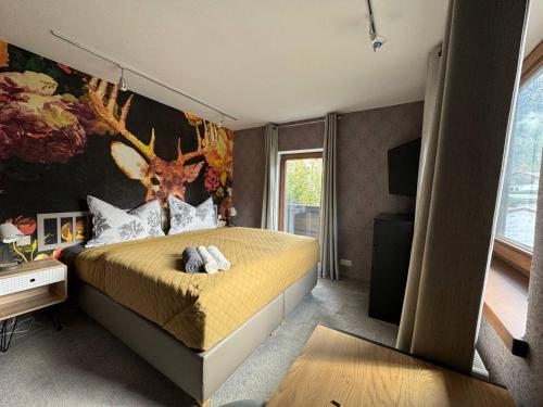 a bedroom with a bed with a deer mural on the wall at Two Brothers Inn in Pertisau