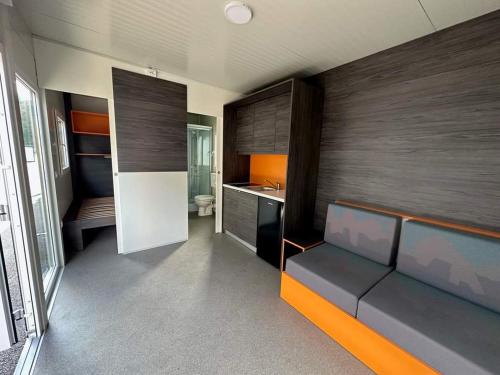 uma cozinha com um sofá e um lavatório num quarto em Mobile home Nelly em Pirovac