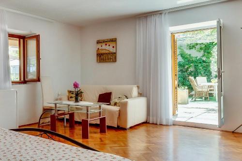 a living room with a couch and a table at House ROSSELLA with cozy apartment and rooms close to the beach in Nerezine