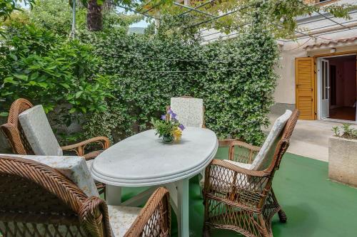 einen Tisch und Stühle auf einer Terrasse in der Unterkunft House ROSSELLA with cozy apartment and rooms close to the beach in Nerezine