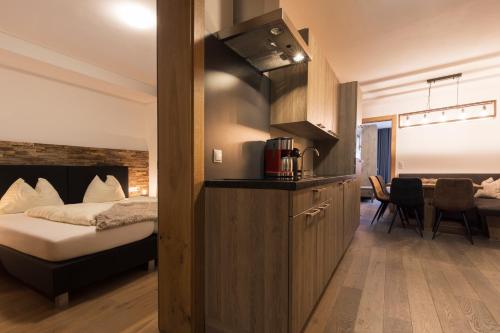 a hotel room with a bed and a kitchen at Aparthotel Herzblick GmbH in See