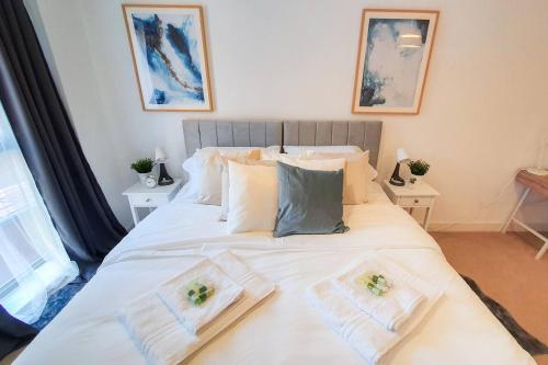 a bedroom with a large white bed with towels on it at Lovely Flat In Kiln Close With Free Parking in Gloucester