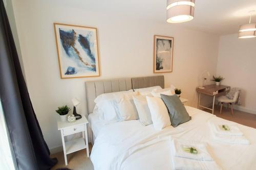 a bedroom with a bed with white sheets and pillows at Lovely Flat In Kiln Close With Free Parking in Gloucester