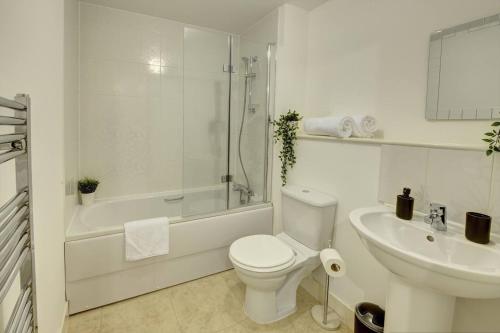 a white bathroom with a toilet and a sink at Lovely Flat In Kiln Close With Free Parking in Gloucester