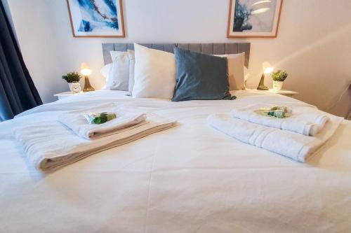 a white bed with towels and candles on it at Lovely Flat In Kiln Close With Free Parking in Gloucester