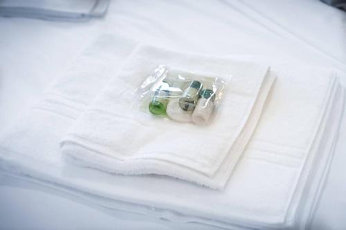 a white towel on a bed with some medicines at Lovely Flat In Kiln Close With Free Parking in Gloucester