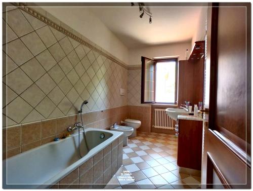 a bathroom with a tub and a toilet and a sink at 3 bedrooms house with private pool terrace and wifi at Abbateggio in Abbateggio