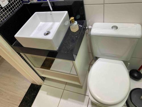 a bathroom with a white toilet and a sink at Apto Lindo/Aconchegante perto da UEL/bares/ centro in Londrina