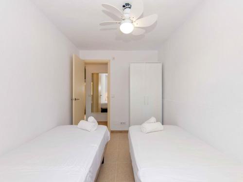 2 camas en una habitación con ventilador de techo en Villa Gavines down, en S'Algar