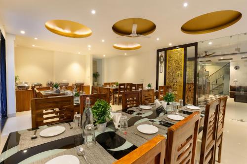 a dining room with a long table and chairs at Denver Paragon Suites Delhi Airport in New Delhi