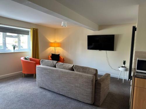 a living room with a couch and a tv at Yellow Sunflowers Flat In Stroud in Stroud