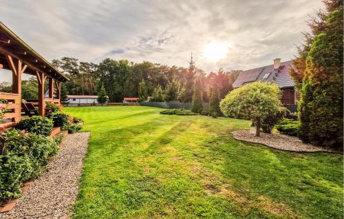 a yard with green grass and a house at Amazing Home In Stepnica With Kitchen in Stepnica