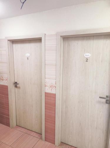two wooden doors in a room with wood floors at Ubytování v klimatizovaných chatičkách Štít in Chlumec nad Cidlinou