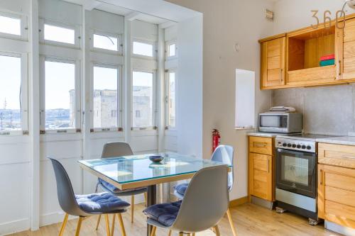 a kitchen with a table with chairs and a microwave at Charming home with Sea views & Maltese Balcony by 360 Estates in Valletta