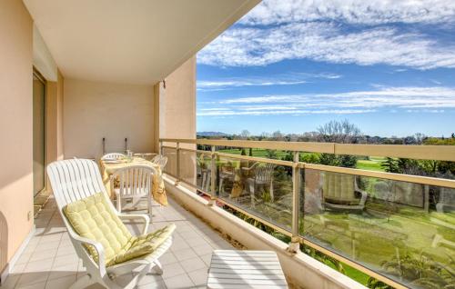 a balcony with chairs and a view of the countryside at Cozy Apartment In Mandelieu-La-Napoule in Mandelieu-la-Napoule