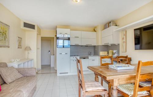 a kitchen and living room with a wooden table and chairs at Cozy Apartment In Mandelieu-La-Napoule in Mandelieu-la-Napoule