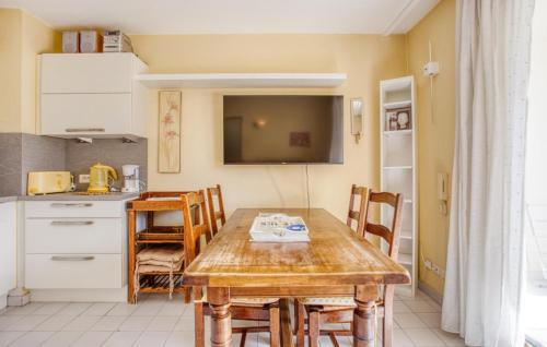une cuisine et une salle à manger avec une table en bois dans l'établissement Cozy Apartment In Mandelieu-La-Napoule, à Mandelieu-la-Napoule