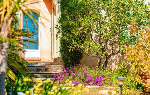 un jardin avec des fleurs violettes en face d'un bâtiment dans l'établissement Awesome Home In Saint-Raphaël With Wifi, à Saint-Raphaël