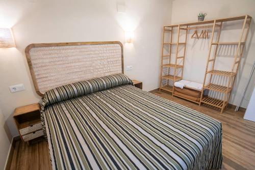 アルデアヌエバ・デル・カミーノにあるComplejo Romaのベッドルーム1室(ストライプのヘッドボード付きのベッド1台付)