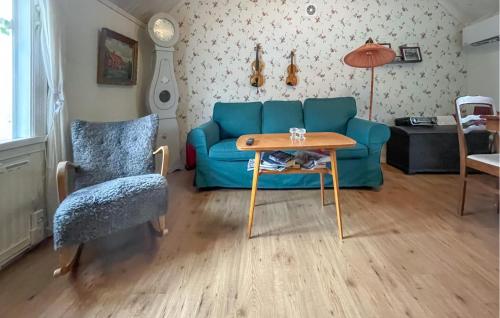 a living room with a blue couch and a table at 3 Bedroom Nice Home In Frillesås in Frillesås
