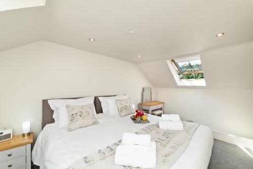 um quarto com uma grande cama branca e 2 almofadas em Ewe Bach Cottage em Llanasa