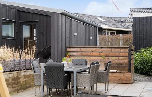 a patio with a table and chairs and a fence at Nice Home In Haderslev With Kitchen in Haderslev
