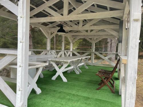 a picnic table and a bench in a pavilion at Miškas Arjola in Kaltanėnai