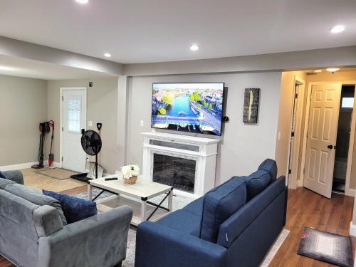 a living room with two blue couches and a tv at Apartment with Brand new furniture and large parking in West Seneca