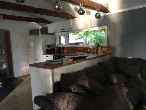 cocina con sofá y encimera en una habitación en Häuschen direkt am See mit Sauna, en Bestensee