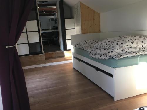 1 dormitorio con cama y espejo en Häuschen direkt am See mit Sauna, en Bestensee