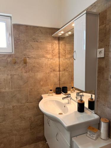 bagno con lavandino e specchio di Apartments Roko a Pridraga