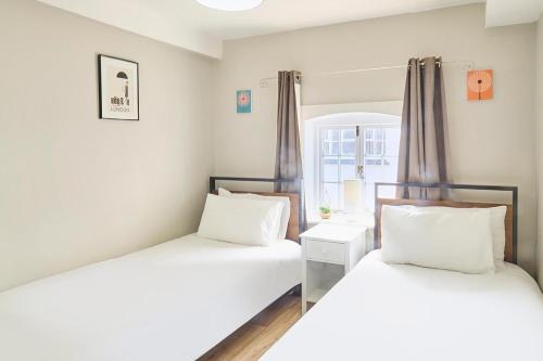 2 Einzelbetten in einem Zimmer mit Fenster in der Unterkunft Host & Stay - Roper Road in Canterbury