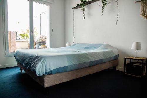 un letto in una camera da letto con una grande finestra di Amazing Flat Roof Top a Saint-Ouen