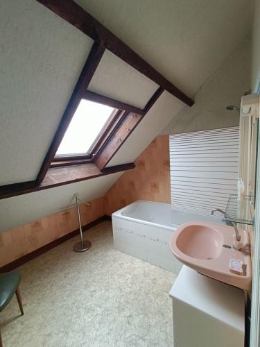 La salle de bains est pourvue d'un lavabo rose et d'une baignoire. dans l'établissement Gîte les Yards, à Yffiniac