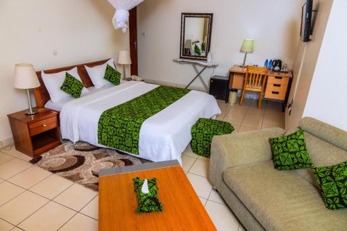a hotel room with a bed and a couch at One Click Hotel in Kigali