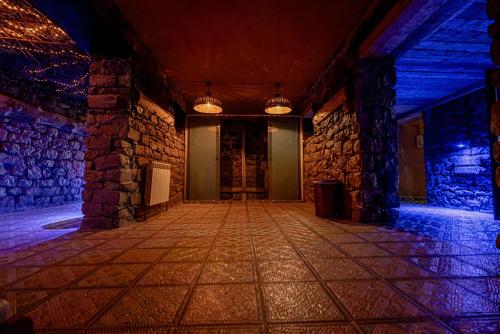 an empty room with a stone wall and lights at Hotel Xaluca Spa Aguelmame Sidi Ali in Aguelman