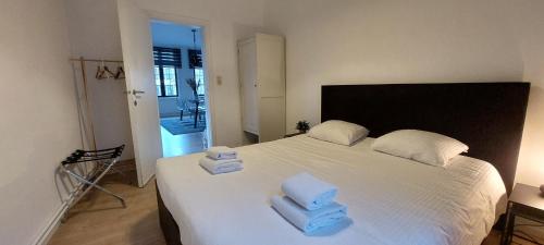 una camera con un letto bianco con tre pile di asciugamani di The View - spacious 2 bdr appt in with view ad Anversa