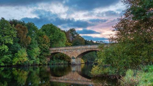 a bridge over a river with reflections in the water at The Cheviot Hotel in Bellingham