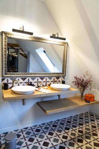 une salle de bain avec deux lavabos et un miroir dans l'établissement La Grande Roche, à Chambellay