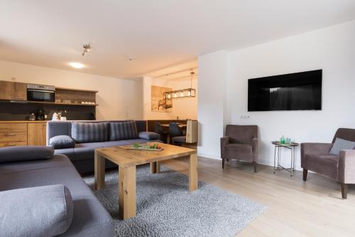 a living room with a couch and a table at Aparthotel Herzblick GmbH in See