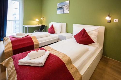 ein Hotelzimmer mit 2 Betten mit roten und weißen Kissen in der Unterkunft Di Verdi Imperial Hotel in Budapest