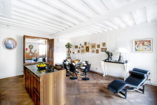 a living room with a table and chairs in it at Ile Saint Louis & Direct River Views - CityApartmentStay in Paris