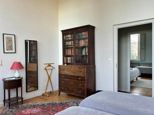 1 dormitorio con tocador de madera y espejo en Chambre d'hôte double 2 en Castelsarrasin