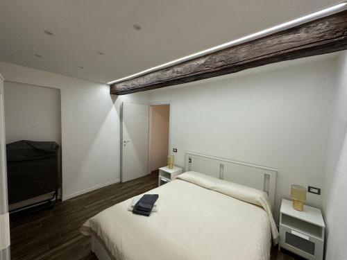 1 dormitorio con 1 cama blanca y TV en Residenza Castellazzo en Ivrea