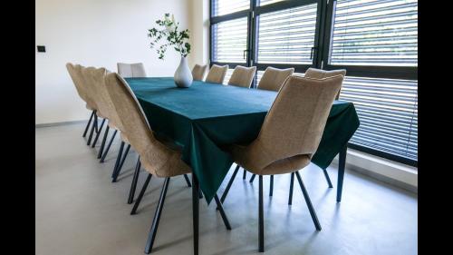 einen Esstisch mit einem grünen Tisch und Stühlen in der Unterkunft Maison 21 in Zutzendorf